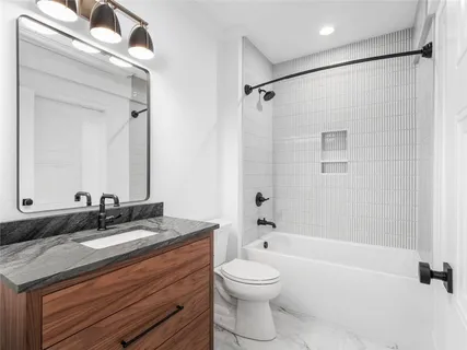 a bathroom with a granite countertop sink a toilet and a mirror