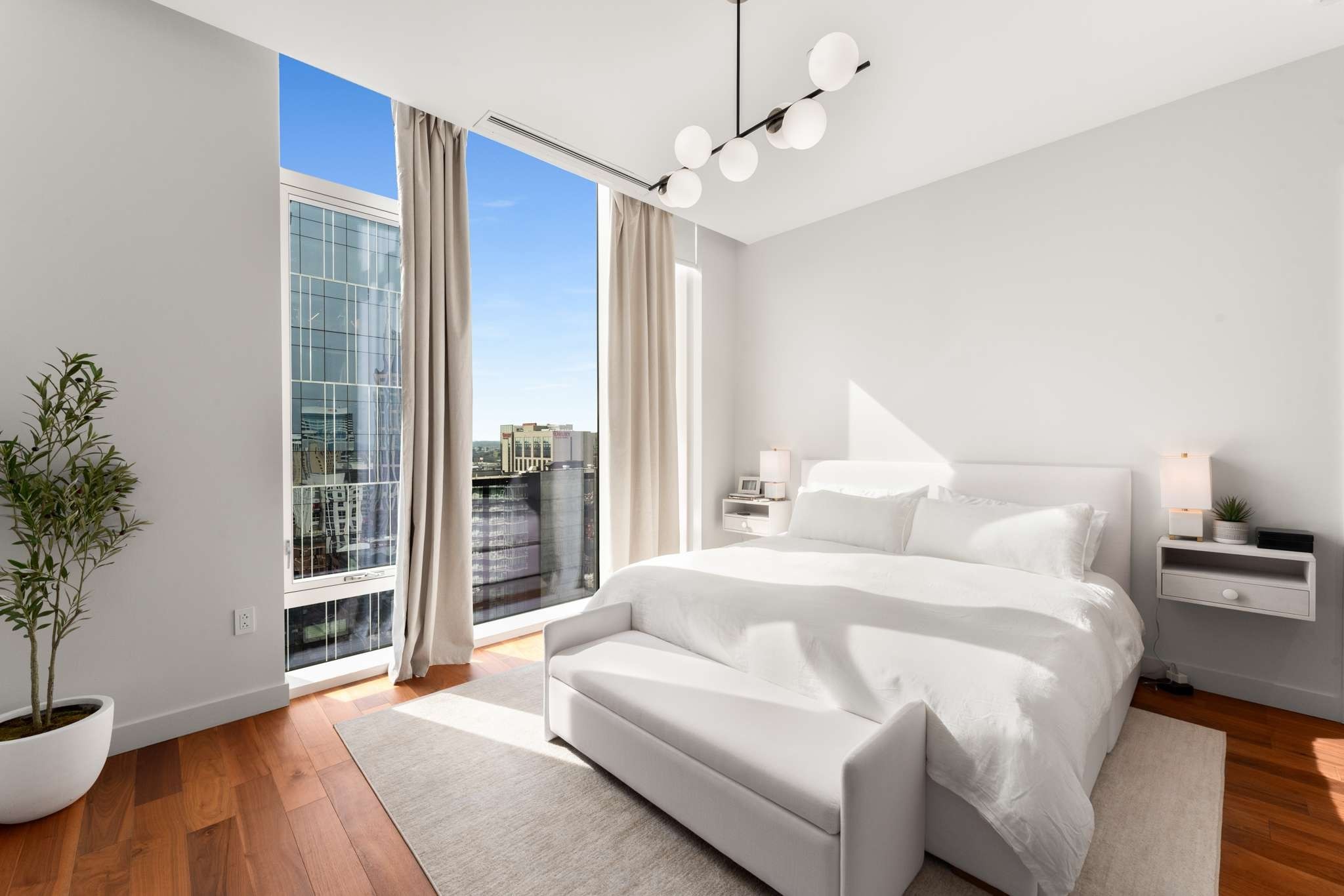 160 2nd Avenue South, Unit 1902 Nashville, TN 37201 - Photo 13 of 40 a spacious bedroom with a bed and a potted plant