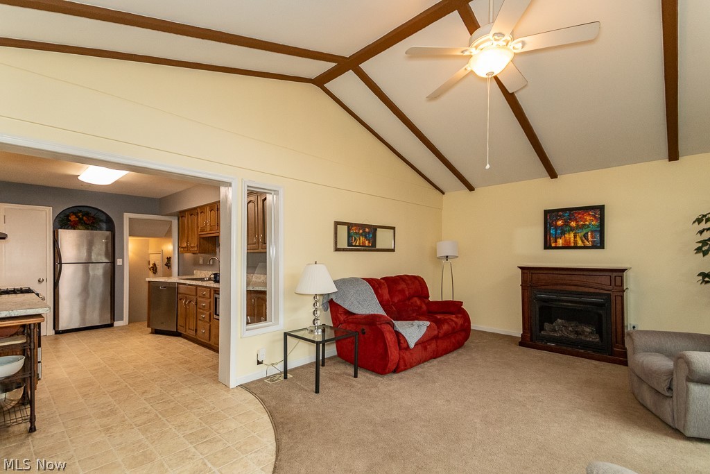 9771 Old Johnnycake Ridge Road Mentor, OH 44060 - Photo 19 of 29 Carpeted living room featuring high vaulted ceiling, ceiling fan, and sink