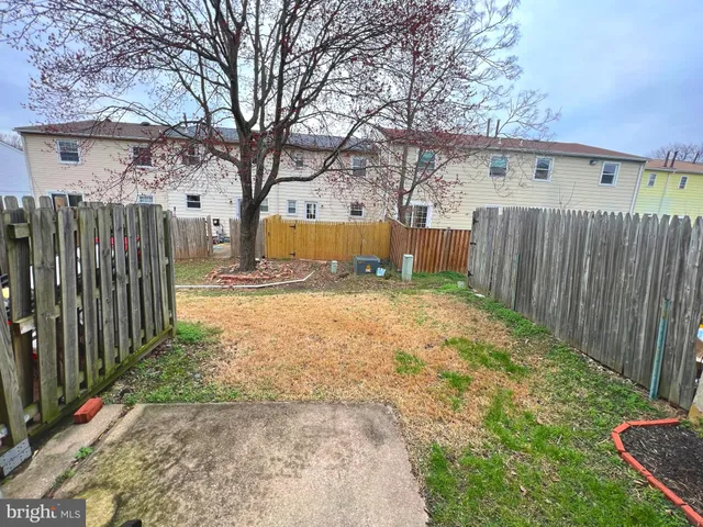 a view of yard with small cabin and wooden fence