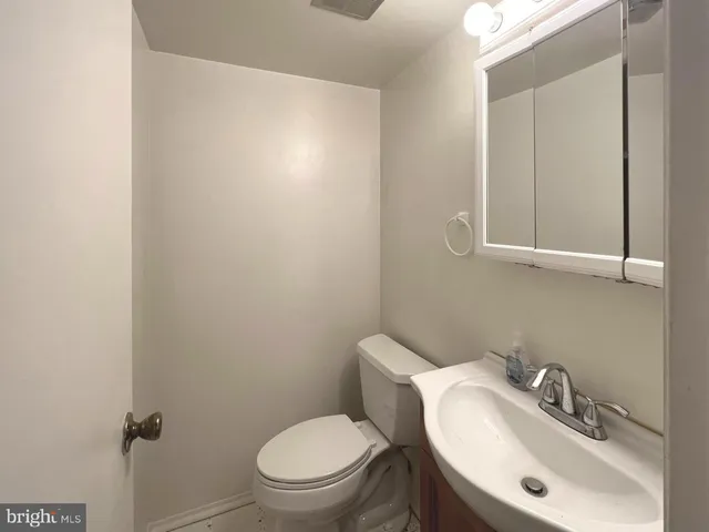 a bathroom with a toilet sink vanity and mirror