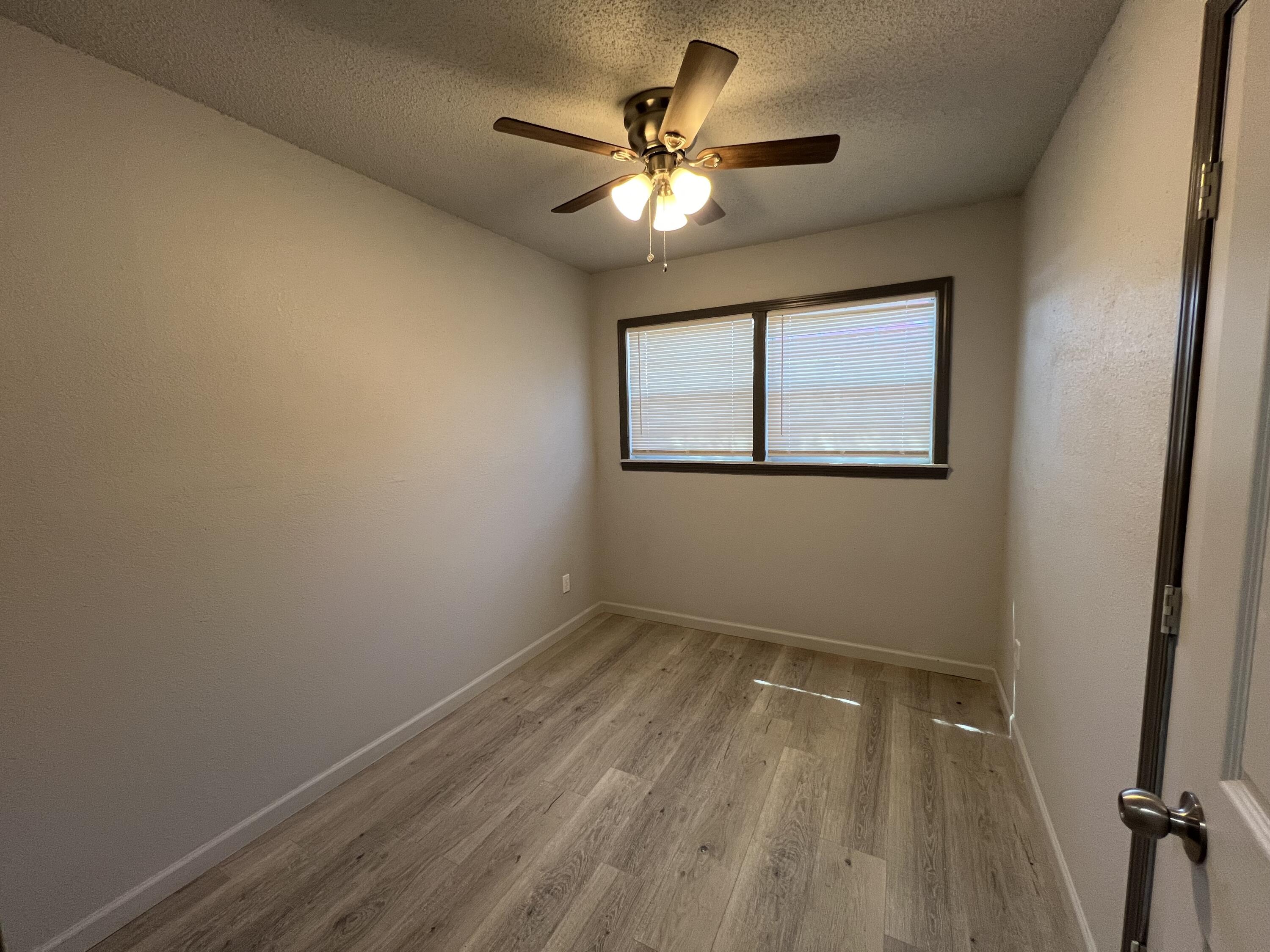 801 Vanda Avenue Lubbock, TX 79403 - Photo 11 of 13 wooden floor in an empty room with a window