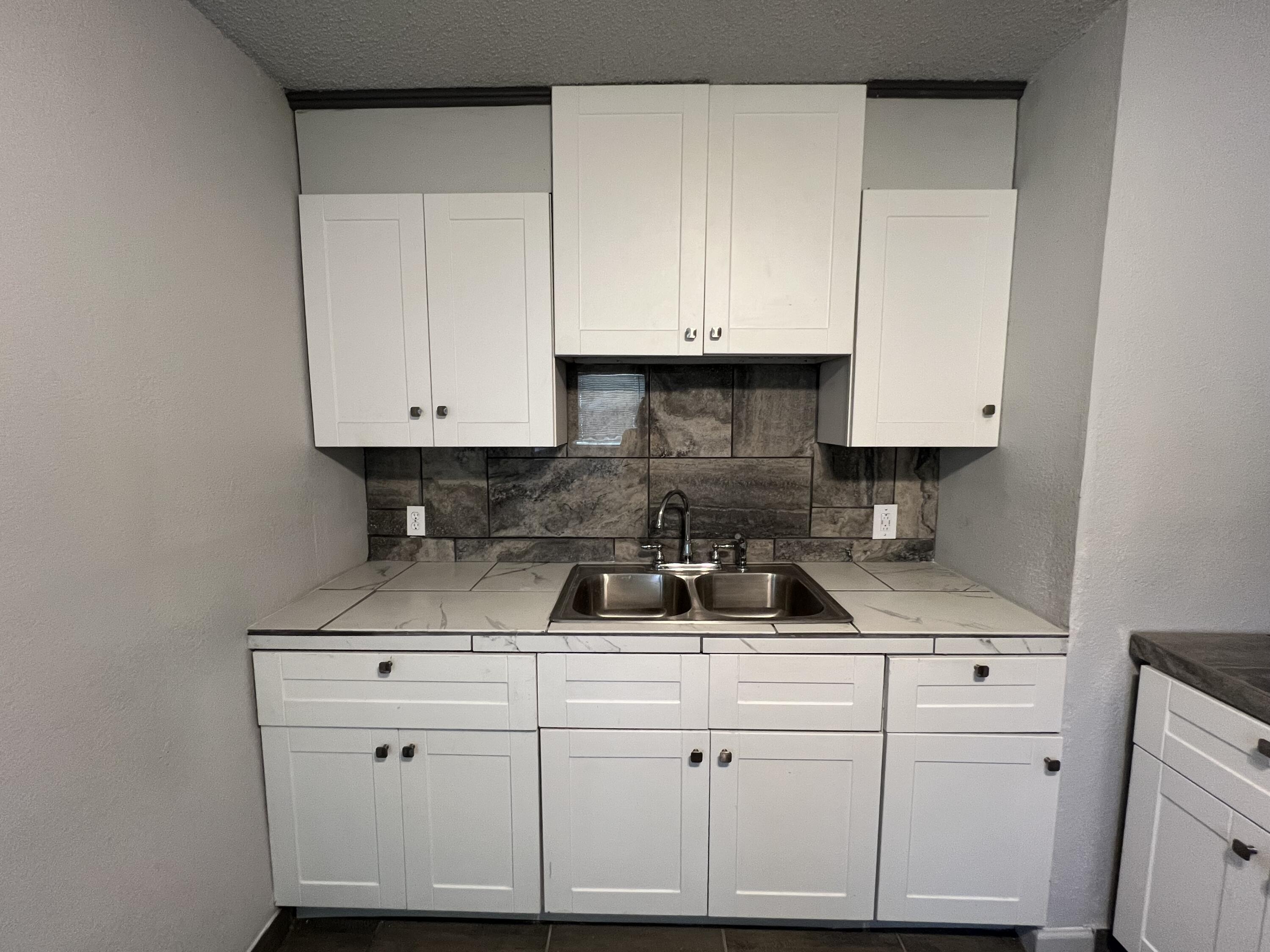 801 Vanda Avenue Lubbock, TX 79403 - Photo 4 of 13 a kitchen with white cabinets and white appliances