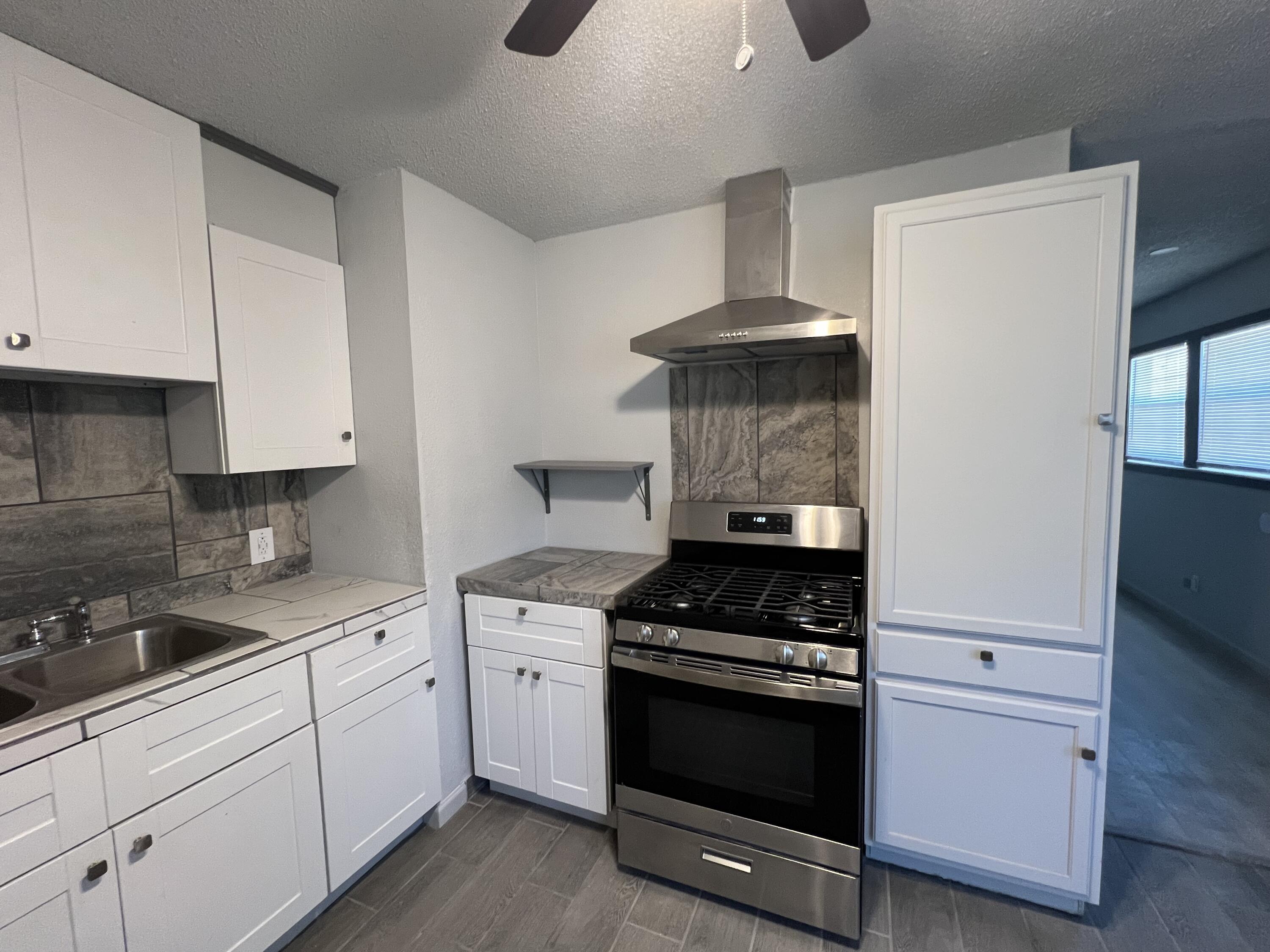 801 Vanda Avenue Lubbock, TX 79403 - Photo 5 of 13 a kitchen with white cabinets and appliances