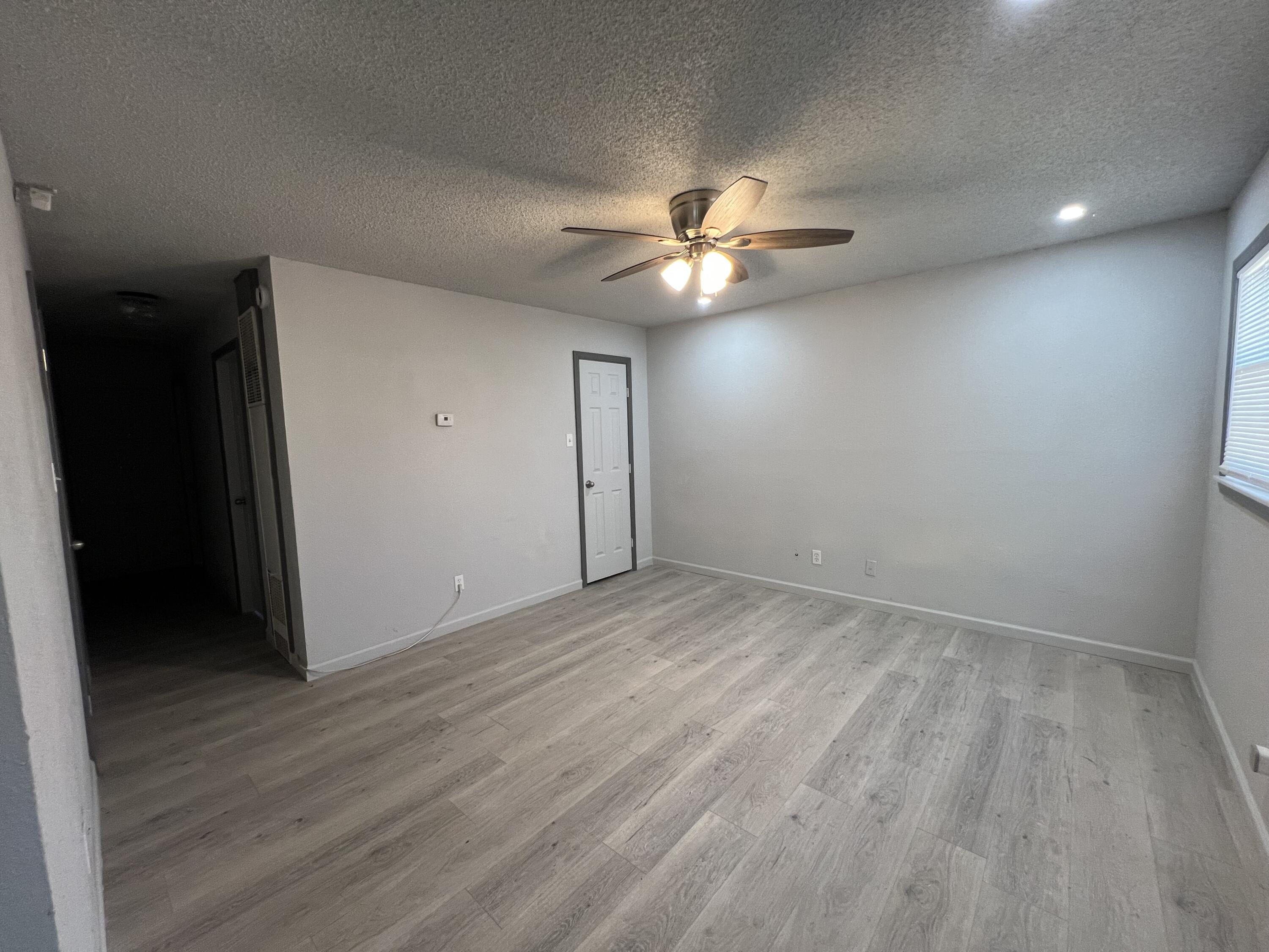 801 Vanda Avenue Lubbock, TX 79403 - Photo 6 of 13 wooden floor in an empty room with a window