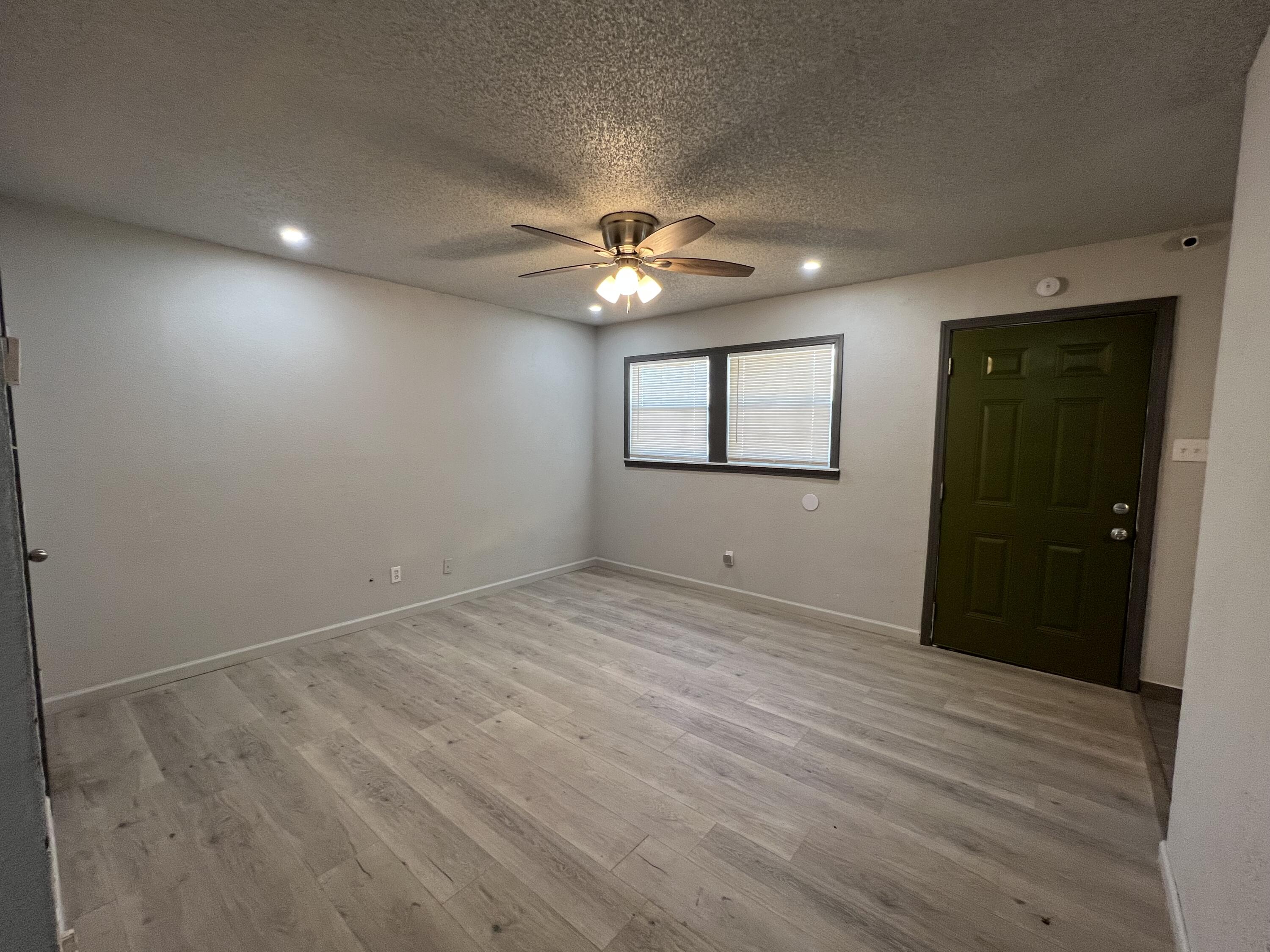 801 Vanda Avenue Lubbock, TX 79403 - Photo 7 of 13 an empty room with chandelier fan and windows