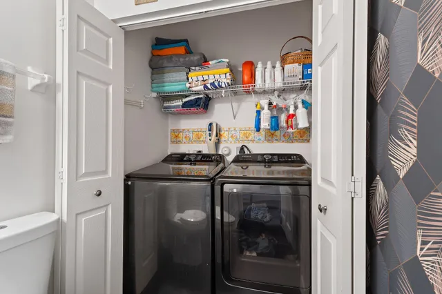 a utility room with stainless steel appliances granite countertop a stove and a refrigerator