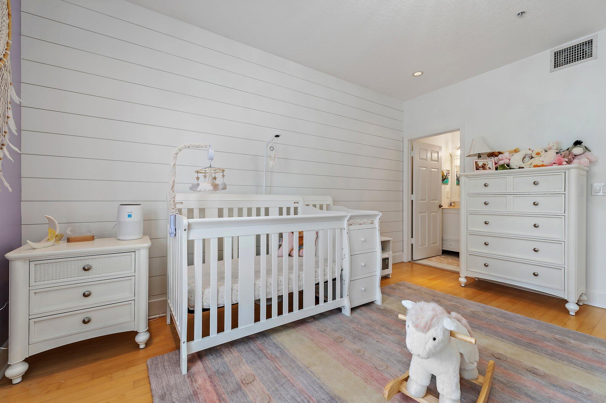 1101 Beach Road, Unit C Palm Beach Shores, FL 33404 - Photo 26 of 44 a view of a bedroom with baby crib and wooden floor