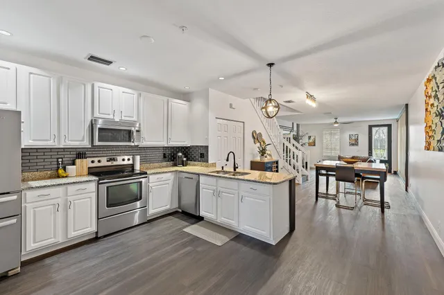 a kitchen with white cabinets and appliances