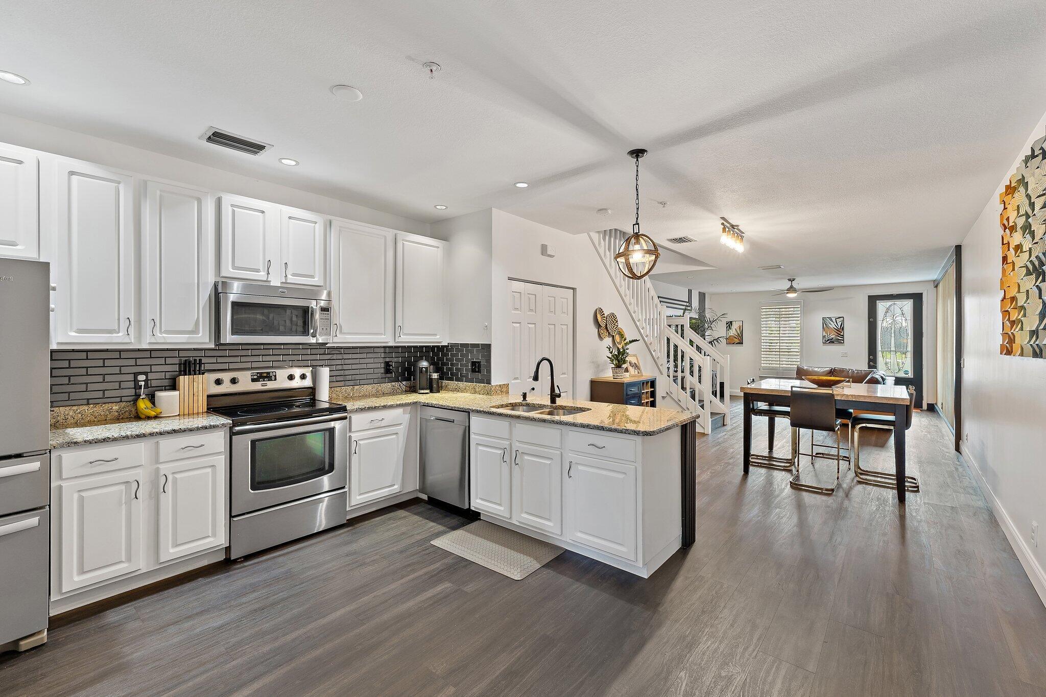 1101 Beach Road, Unit C Palm Beach Shores, FL 33404 - Photo 7 of 44 a kitchen with white cabinets and appliances