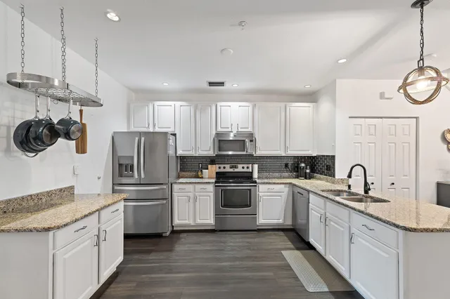 a kitchen with a sink a refrigerator a stove and cabinets