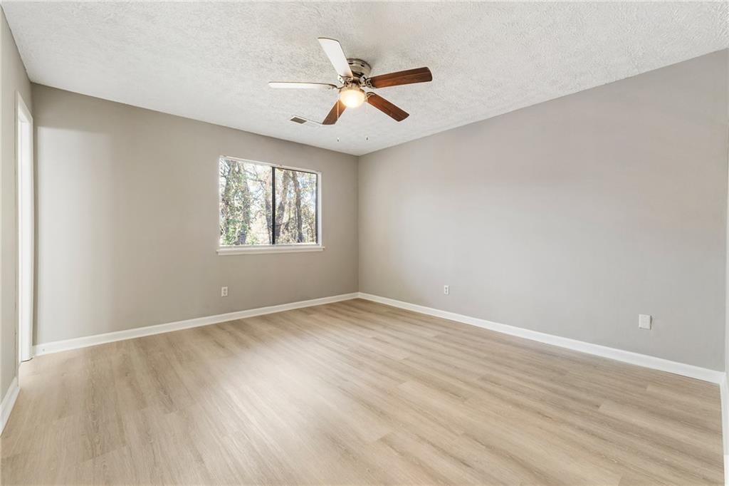 130 Forrest View Terrace Johns Creek, GA 30022 - Photo 19 of 34 an empty room with wooden floor fan and windows