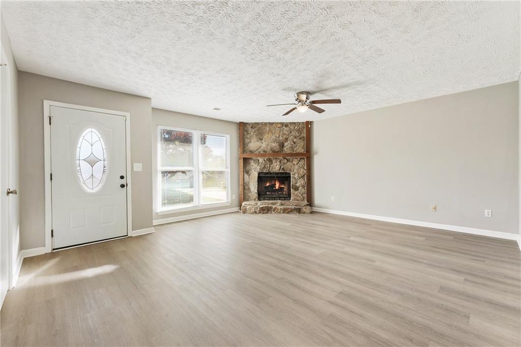 130 Forrest View Terrace Johns Creek, GA 30022 - Photo 3 of 34 an empty room with wooden floor fireplace and windows