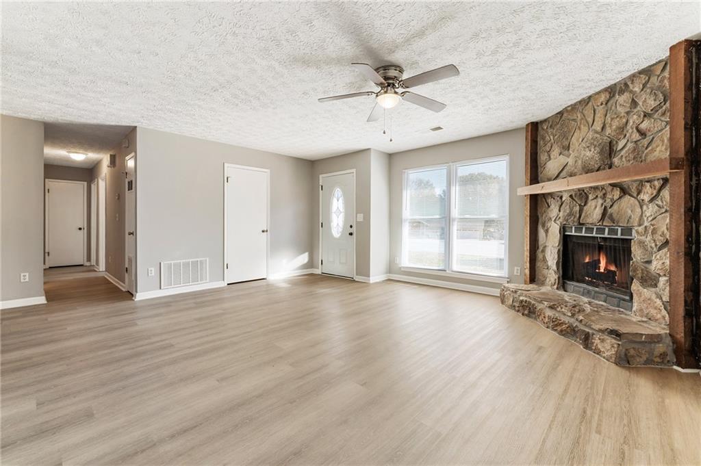 130 Forrest View Terrace Johns Creek, GA 30022 - Photo 5 of 34 a view of an empty room with wooden floor fireplace and a window