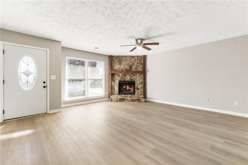130 Forrest View Terrace Johns Creek, GA 30022 - Photo 6 of 34 an empty room with windows cabinet and fireplace