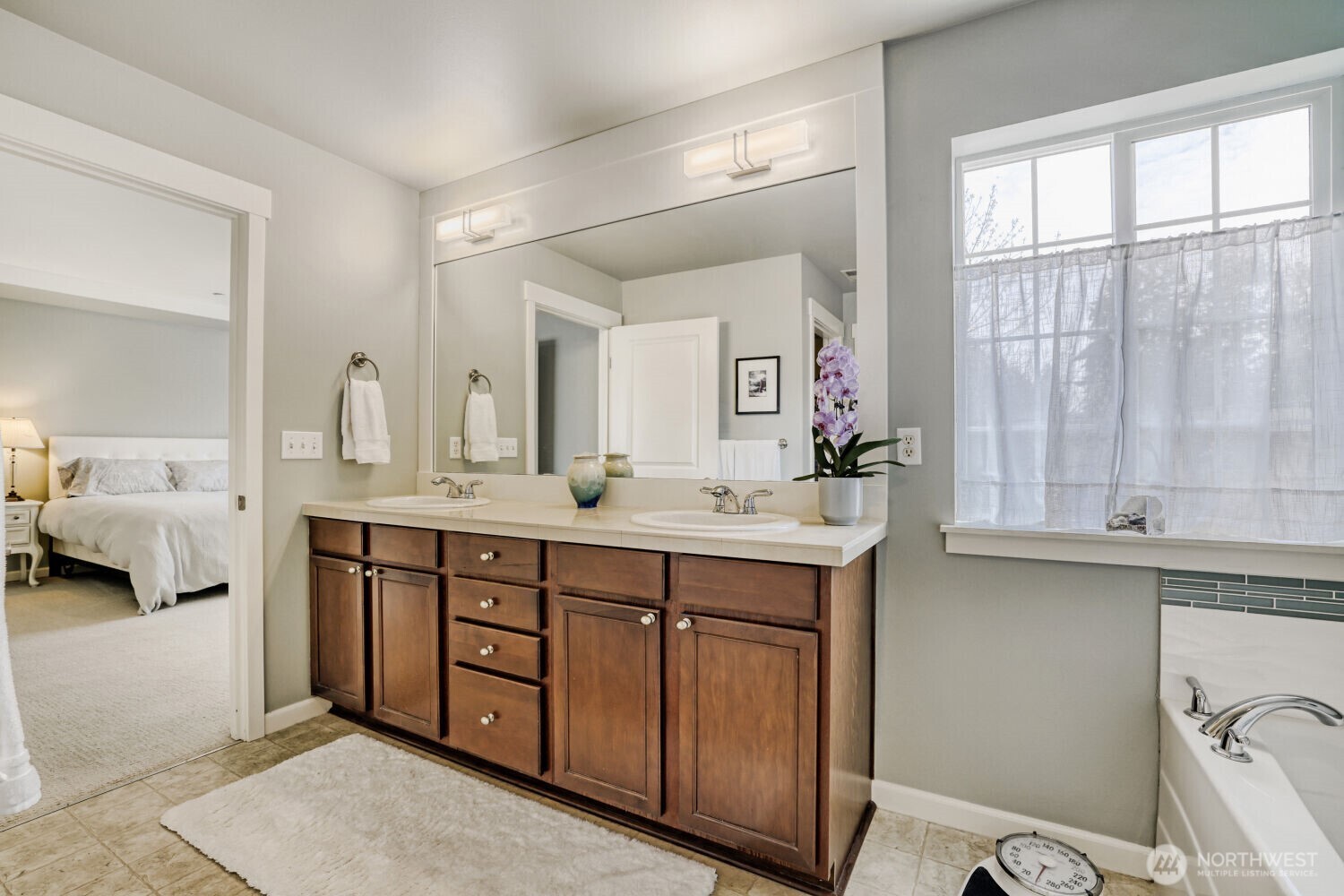 18705 101st Avenue Northeast, Unit 3 Bothell, WA 98011 - Photo 25 of 31 a spacious bathroom with a double vanity sink a mirror and a shower