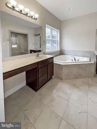 a spacious bathroom with a tub sink and mirror