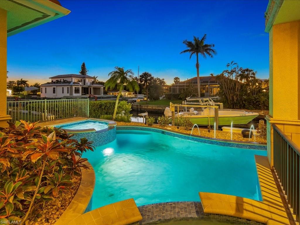 1550 Mullet Lane Naples, FL 34102 - Photo 12 of 50 a view of a lake with a house in the background