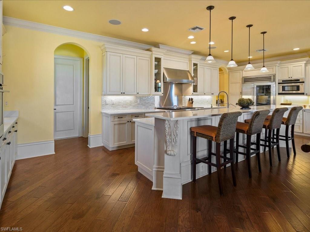 1550 Mullet Lane Naples, FL 34102 - Photo 22 of 50 a kitchen with stainless steel appliances granite countertop a table chairs sink and stove