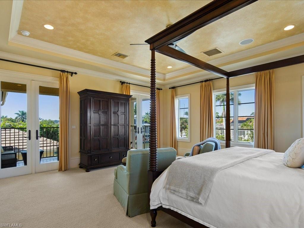 1550 Mullet Lane Naples, FL 34102 - Photo 36 of 50 a bedroom with a large bed and large windows