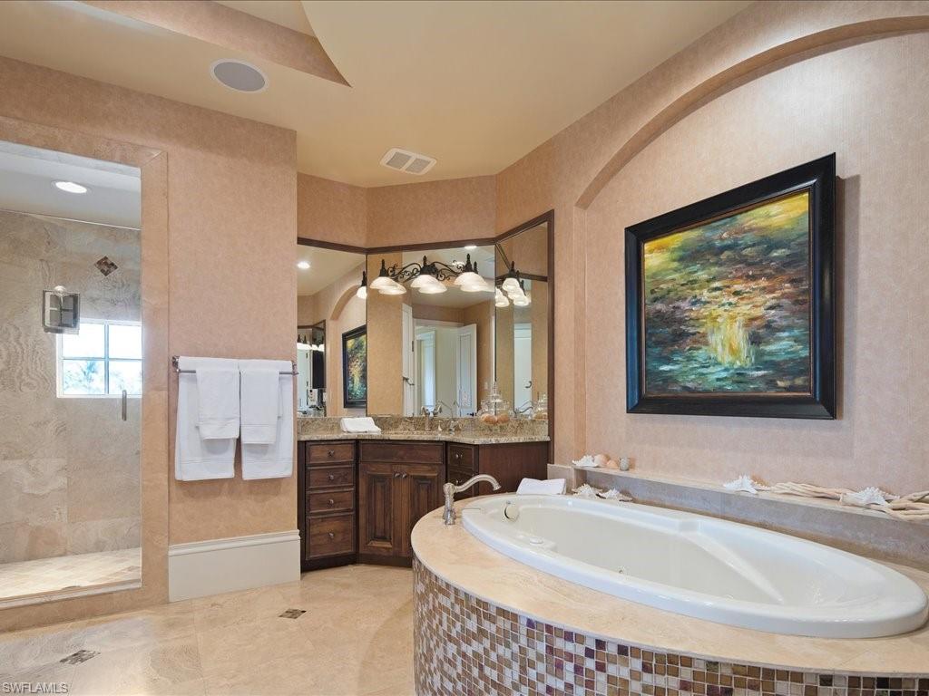 1550 Mullet Lane Naples, FL 34102 - Photo 40 of 50 a bathroom with a tub sink and mirror