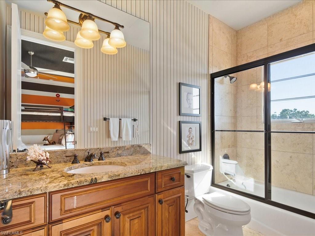 1550 Mullet Lane Naples, FL 34102 - Photo 46 of 50 a bathroom with a granite countertop sink toilet and shower