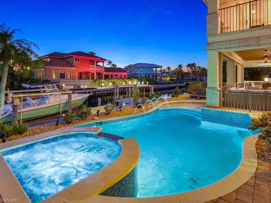 1550 Mullet Lane Naples, FL 34102 - Photo 9 of 50 a view of a swimming pool with lawn chairs