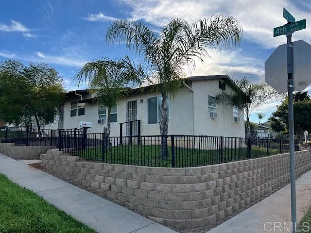 a view of a white house with a small yard and a large tree
