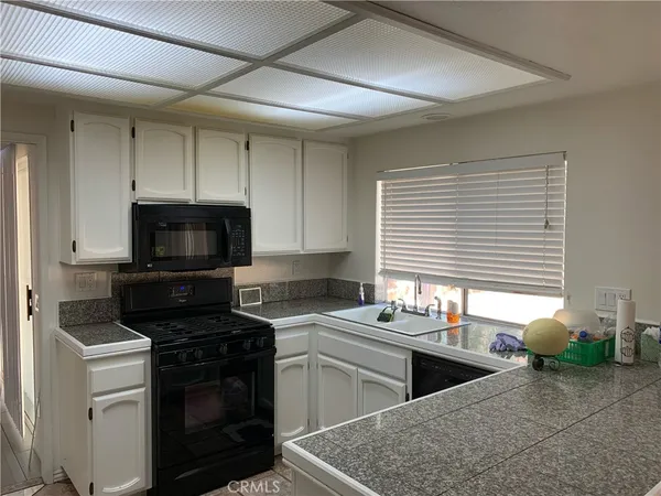 a kitchen with stainless steel appliances granite countertop a sink stove and microwave