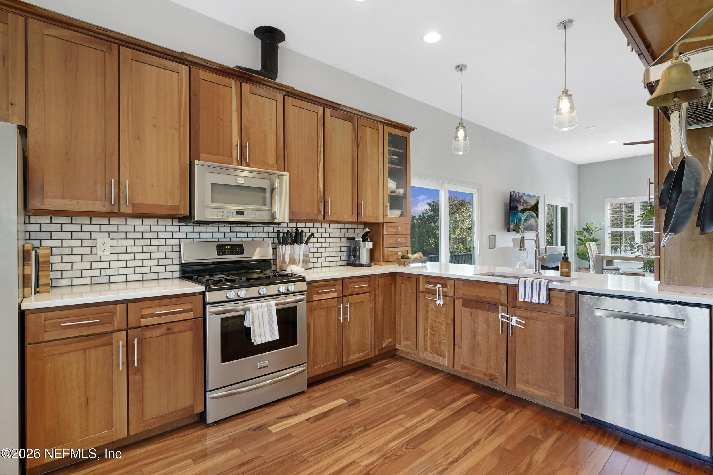 3336 Carmel Road St. Augustine, FL 32086 - Photo 10 of 55 a kitchen with stainless steel appliances granite countertop a stove a sink dishwasher and a microwave oven with wooden floor