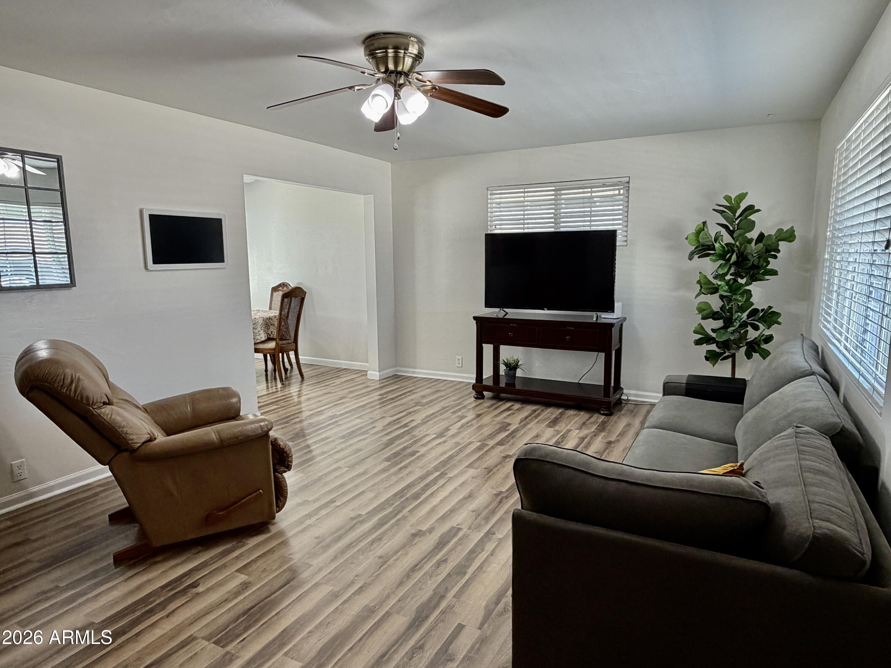 543 West 18th Street Tempe, AZ 85281 - Photo 3 of 29 a living room with furniture a flat screen tv and a potted plant