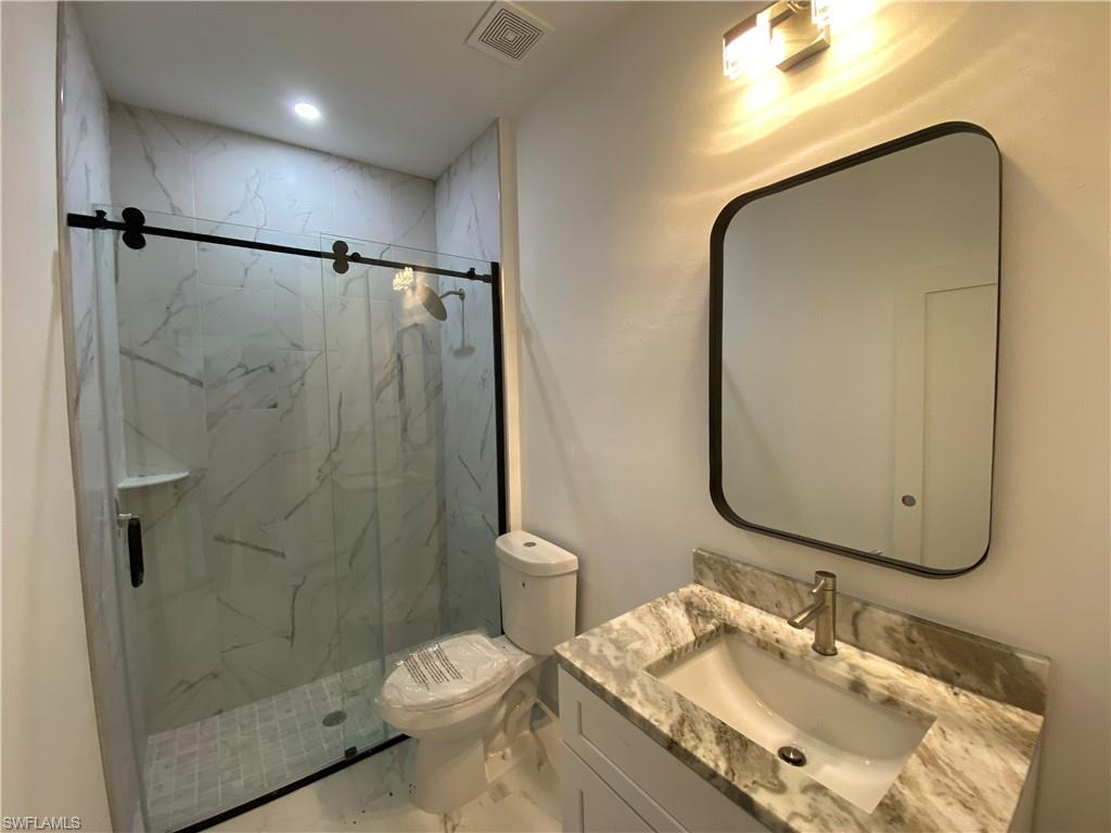 5444 Billings Street Lehigh Acres, FL 33971 - Photo 11 of 32 a bathroom with a granite countertop sink toilet and shower