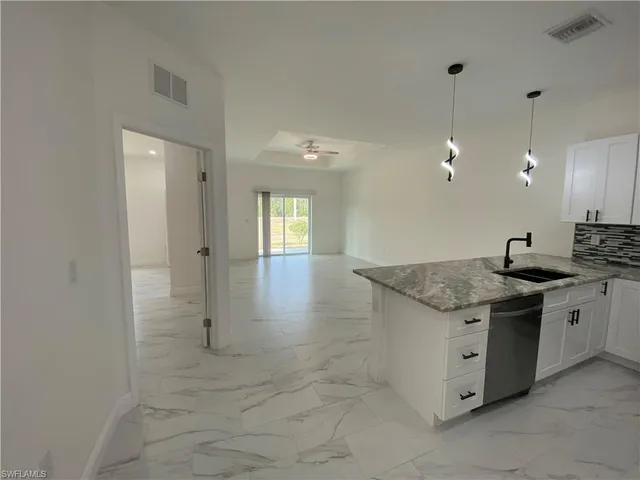 a kitchen with granite countertop a sink and a stove