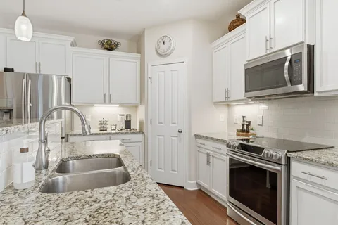 a kitchen with stainless steel appliances granite countertop a sink stove and microwave