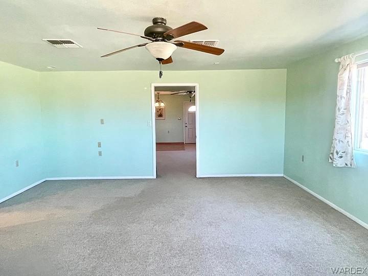 21477 South Sundance Kid Road Yucca, AZ 86438 - Photo 29 of 66 an empty room with a ceiling fan and a window