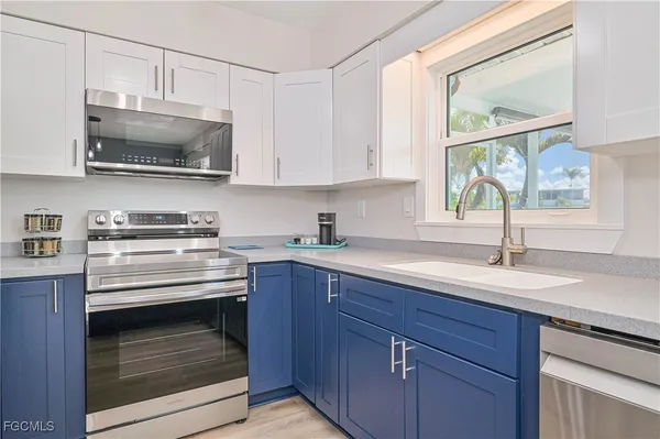 a kitchen with stainless steel appliances a stove sink and microwave
