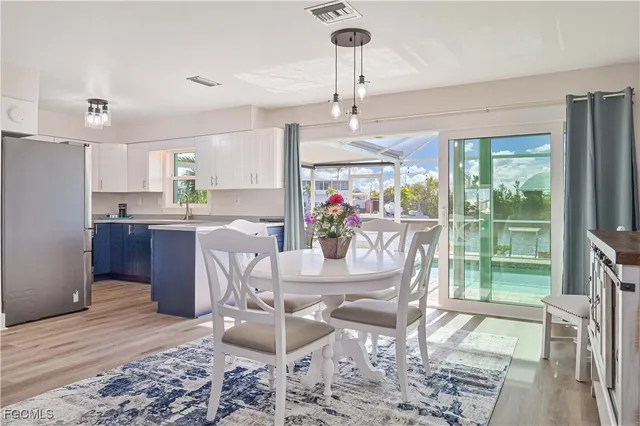 a dining room with furniture a chandelier and wooden floor