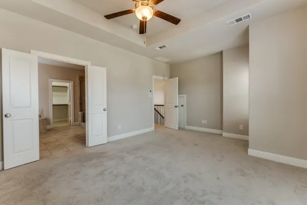 a view of an empty room and a ceiling fan