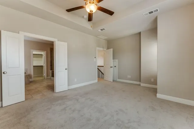 a view of an empty room and a ceiling fan