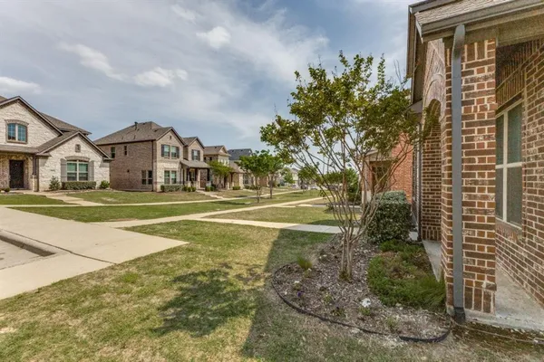 a view of a house with a big yard and large trees