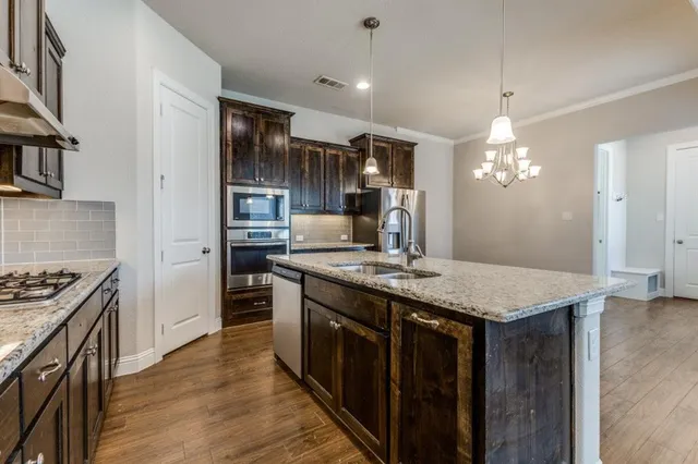 a kitchen with a stove and a wooden floor