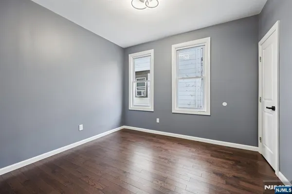 a view of a room with wooden floor and windows