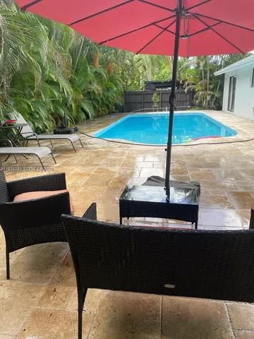 a view of a patio with a table and chairs under an umbrella