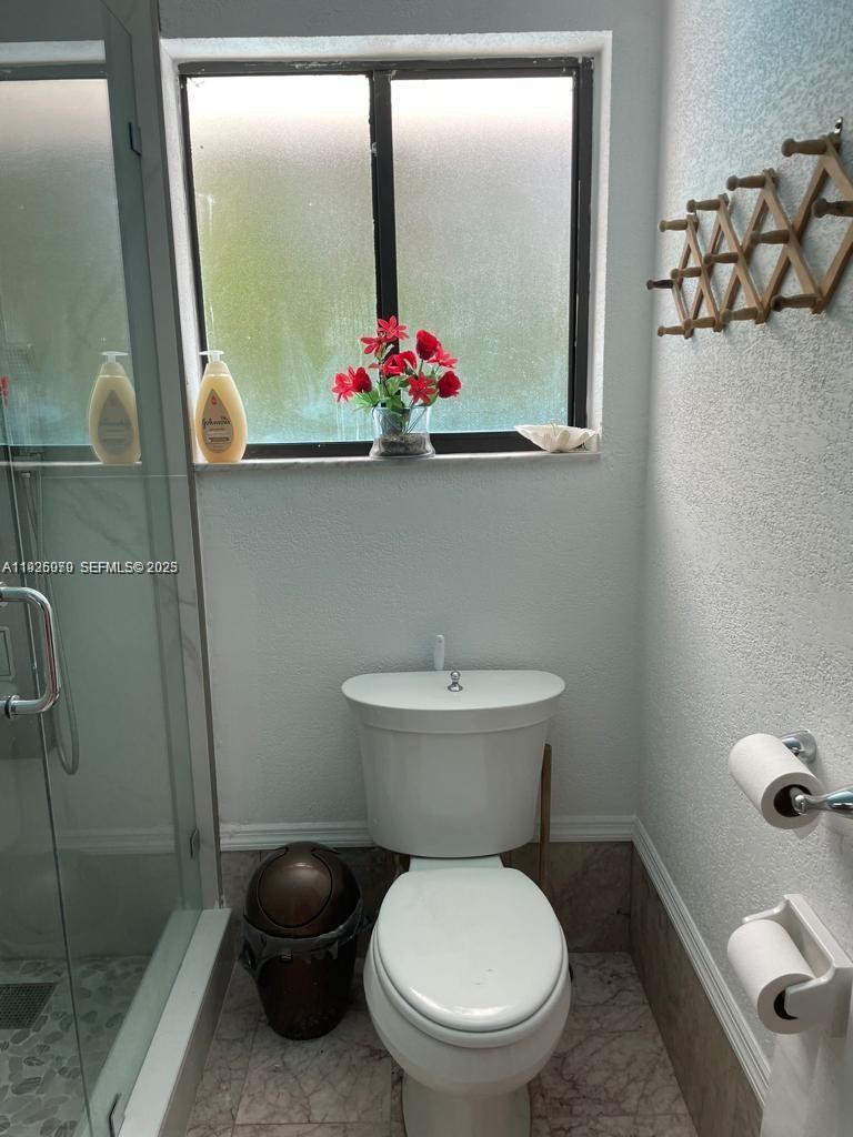 13424 Southwest 90th Terrace Miami, FL 33186 - Photo 9 of 14 a white toilet sitting next to a bathroom sink