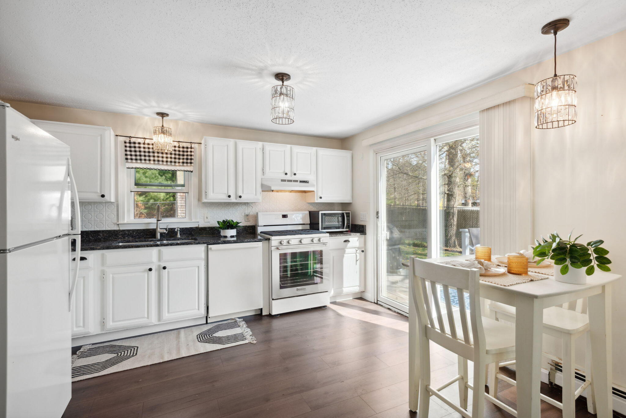 67 Degrass Road Mashpee, MA 02649 - Photo 9 of 24 a kitchen with stainless steel appliances granite countertop a stove a sink dishwasher a refrigerator and white cabinets with wooden floor