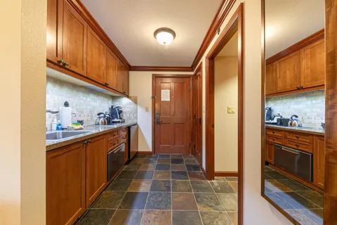 a kitchen with stainless steel appliances granite countertop a refrigerator a stove and a sink with cabinets