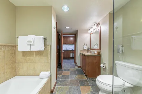 a bathroom with a sink a toilet a mirror and shower