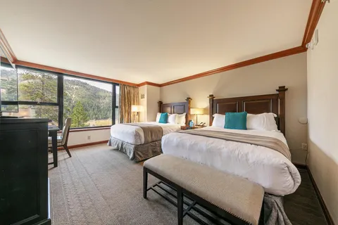 a bedroom with two beds and large window