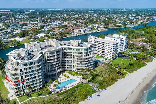 a living room with large couches chandelier and a large window