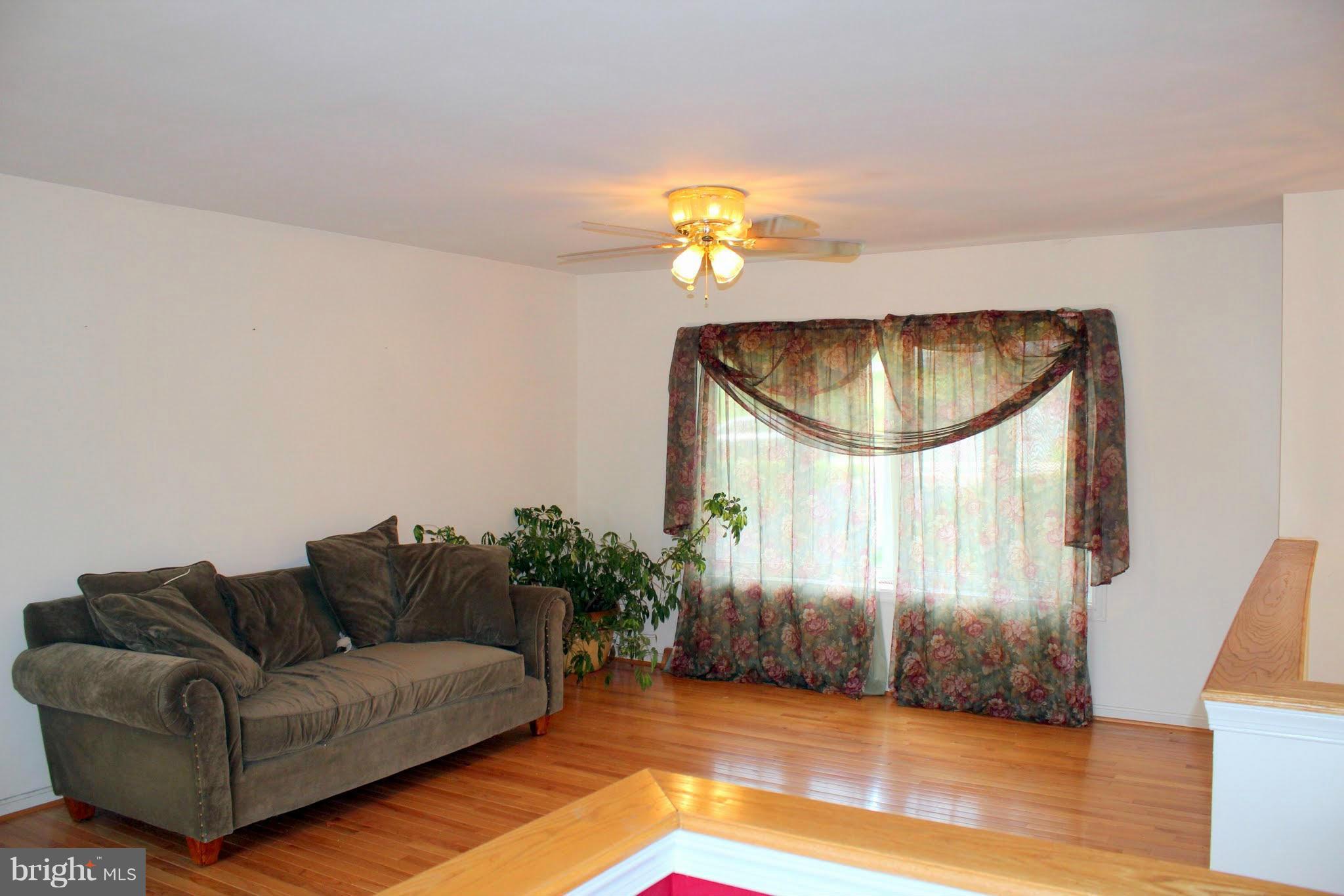 2416 Raintree Avenue Westminster, MD 21157 - Photo 12 of 27 a living room with furniture flowerpot and wooden floor